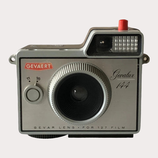 A Gevaert Gevalux 144 35mm film camera with a black and gray body, showing signs of wear.