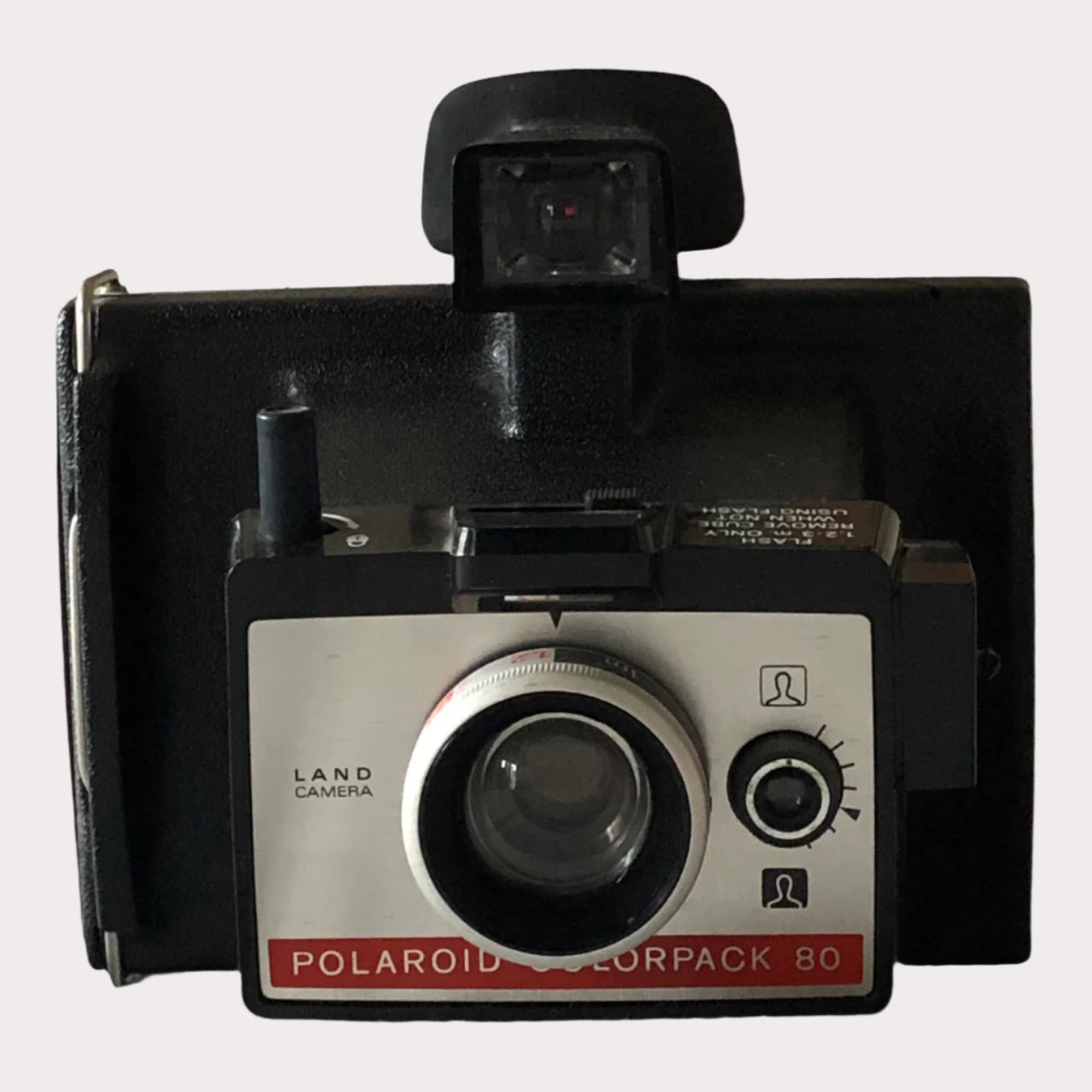 A Polaroid Colorpack 80 camera with a black body and a visible lens, viewed from the front with a close-up on the lens area.
